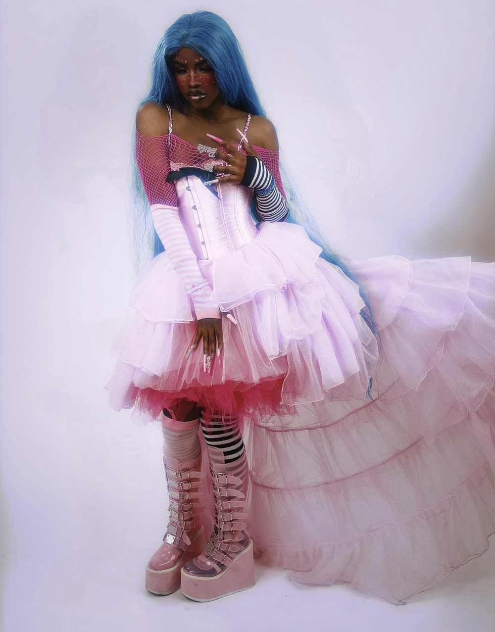 AKA Ezzy seated in a pink and white studio look